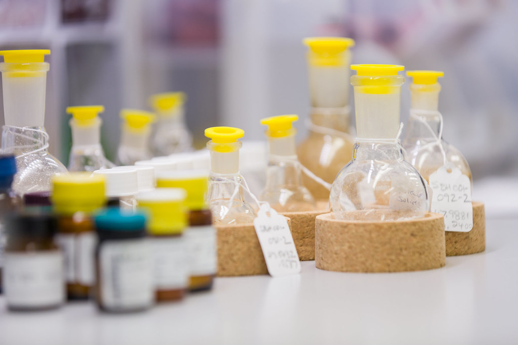Glass bottles with yellow caps arranged on a laboratory workbench